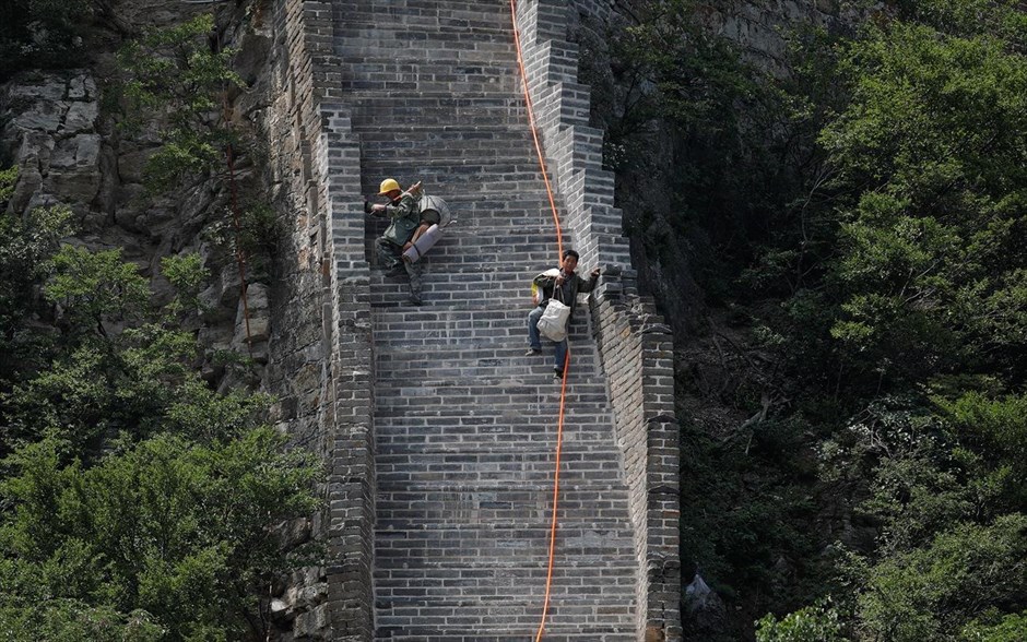 Κίνα: «Ξαναχτίζοντας» το Σινικό Τείχος . Οι εργάτες μεταφέρουν τα εργαλεία τους στην κορυφή. 
