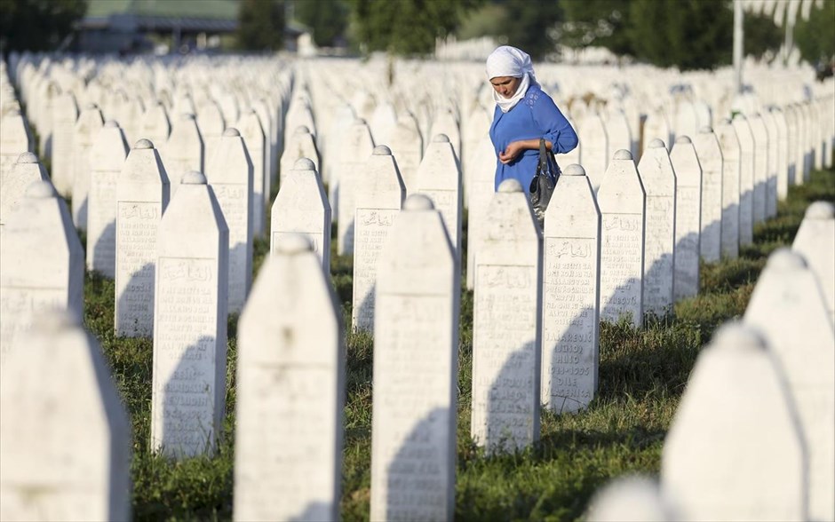 Βοσνία: 22η επέτειος της σφαγής στη Σρεμπρένιτσα. Μια γυναίκα περπατά ανάμεσα στους τάφους των θυμάτων της σφαγής στο Ποτοτσάρι. Η σφαγή στη Σρεμπρένιτσα, που χαρακτηρίζεται γενοκτονία από τη διεθνή δικαιοσύνη, έλαβε χώρα τον Ιούλιο του 1995, μερικούς μήνες πριν από το τέλος του πολέμου της Βοσνίας (1992-1995). Οι σερβικές δυνάμεις της Βοσνίας σφαγίασαν περίπου 8.000 Βόσνιους μουσουλμάνους άνδρες και εφήβους, στη χειρότερη σφαγή που διαπράχθηκε στην Ευρώπη μετά τον Β