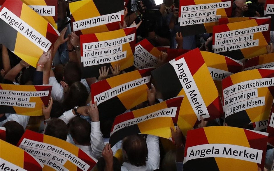 Γερμανία - Εκλογές - CDU - Μέρκελ. People hold placards while waiting for Christian Democratic Union CDU party leader and German Chancellor Angela Merkel to react on first exit polls in the German general election (Bundestagswahl) in Berlin, Germany, September 24, 2017. REUTERS/Pawel Kopczynski