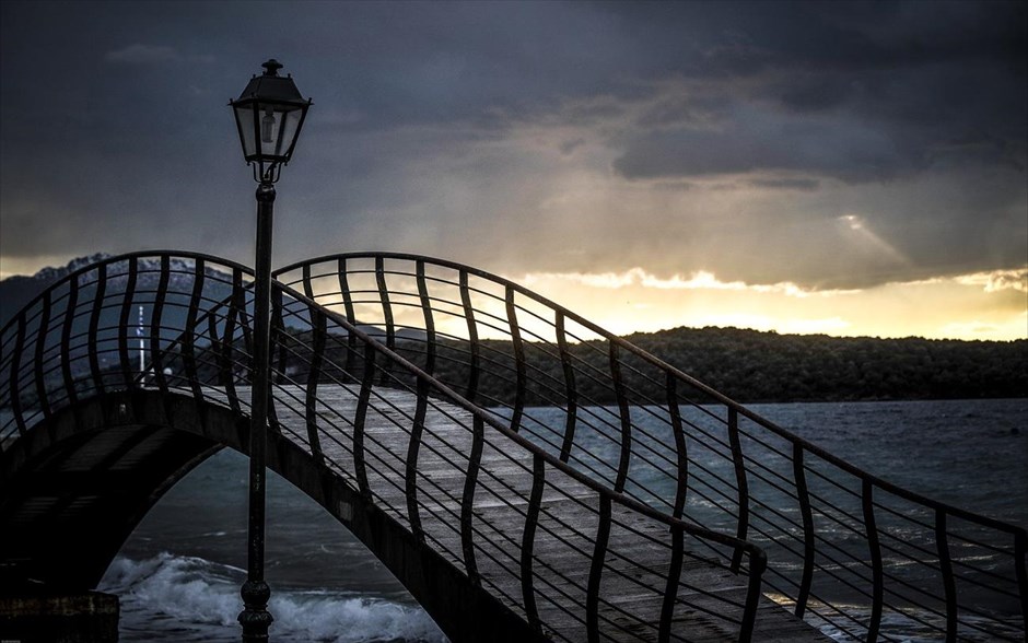 Εκδρομή στο Πήλιο. Η μεταλλική γέφυρα στην παραλία στην Μηλίνα Πηλίου. Η Μηλίνα αποτελεί ένα παραθαλάσσιο τουριστικό θέρετρο των δυτικών ακτών του Πηλίου. Είναι ένα μικρό χωριουδάκι δημοφιλές στους κύκλους των ιστιοπλόων για το απάνεμο αραξοβόλι του. Το τοπωνύμιο προέρχεται από τη σλαβική λέξη «μλιν» που σημαίνει νερόμυλος.