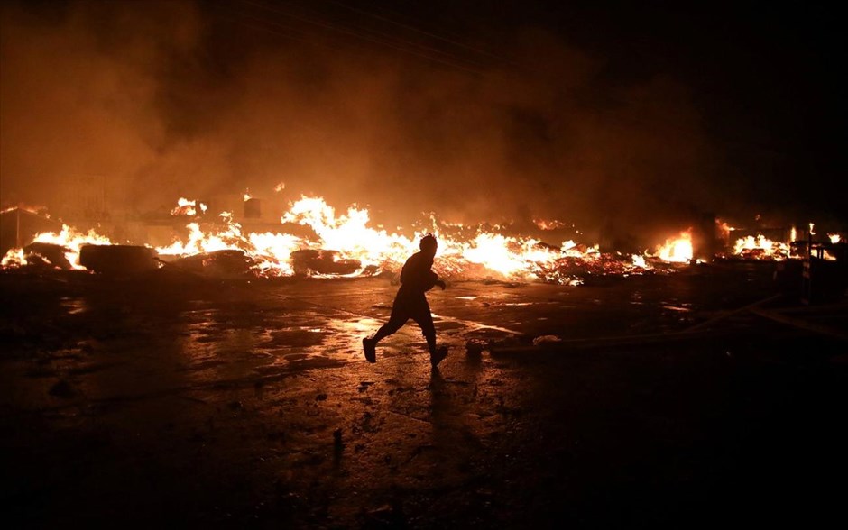 Πυρκαγιά στο Πορτ-ο-Πρενς. Ένας άντρας τρέχει για να σωθεί, μετά από πυρκαγιά που ξέσπασε σε υπαίθρια αγορά στο&nbsp;Πορτ-ο-Πρενς της Αιτής.