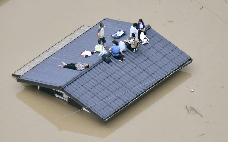 Καταρρακτώδεις βροχές στην Ιαπωνία. Κόσμος έχει συγκεντρωθεί στη σκεπή ενός σπιτιού στην πλημμυρισμένη πόλη Κουρασίκι στην Ιαπωνία. Η χώρα τις τελευταίες μέρες πλήττεται από καταρρακτώδεις βροχοπτώσεις οι οποίες έχουν στοιχίσει τη ζωή σε 38 ανθρώπους ενώ αγνοούνται ακόμα 50. 