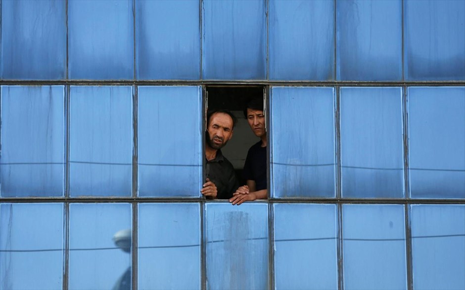 Έκρηξη στην Καμπούλ. Δύο άντρες παρακολουθούν από το παράθυρο ενός σπιτιού το σημείο όπου νωρίτερα&nbsp;ένας βομβιστής αυτοκτονίας φέρεται να ανατινάχθηκε μπροστά από ένα εκπαιδευτικό κέντρο σε μια κυρίως σιιτική περιοχή δυτικά της αφγανικής πρωτεύουσας Καμπούλ. Από την επίθεση έχασαν τη ζωή τους τουλάχιστον 25 άνθρωποι.