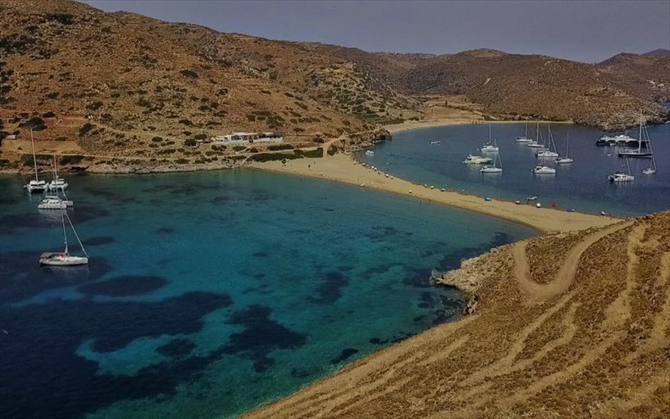 Κυκλαδίτικη καρτ ποστάλ . Φωτογραφία που δόθηκε σήμερα στη δημοσιότητα και εικονίζει την παραλία της Κολώνας στο κυκλαδίτικο νησί της Κύθνου. Η παραλία της Κολώνας είναι ξεχωριστή κυρίως λόγω της γεωμορφολογικής ιδιαιτερότητας της. Πρόκειται στην ουσία για μια αμμουδιά, μήκους 240 μέτρων περίπου, που ενώνει το νησί της Κύθνου με μια μικρή βραχονησίδα, αυτή του Αγίου Λουκά. Η λωρίδα της αμμουδιάς που ενώνει τις δύο στεριές προσομοιάζει με κολώνα, έτσι προκύπτει εξάλλου και η ονομασία της. Η θάλασσα βρέχει και τις δύο πλευρές της λωρίδας άμμου, με αποτέλεσμα να προκύπτουν δύο παραλίες με κοινή αμμουδιά, δημιουργώντας μια ξεχωριστή εικόνα.