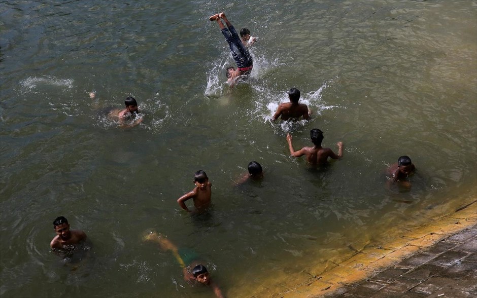 Ανάσες δροσιάς . Παιδιά κολυμπούν σε λίμνη της Ντάκα, στο Μπανγκλαντές.