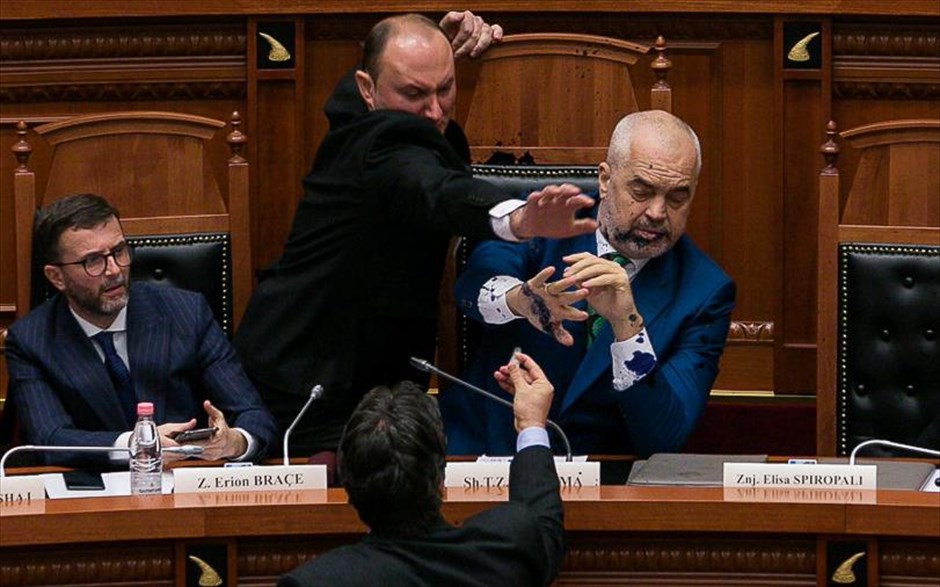 Κοινοβουλευτική συνεδρίαση με πολλά... μελανά σημεία . Το Κοινοβούλιο της Αλβανίας ανέστειλε συνεδρίαση για την ένταξη της Βόρειας Μακεδονίας στο ΝΑΤΟ, όταν ο βουλευτής του Δημοκρατικού Κόμματος, Έντι Παλόκα, έριξε μελάνι στον πρωθυπουργό Έντι Ράμα. Η αιτία; Σύμφωνα με την αντιπολίτευση, «ο πρωθυπουργός δεν σταματούσε να τον κοροϊδεύει για τον τρόπο που μιλούσε. Η επίθεση ήταν η απάντηση του Παλόκα για τον εκφοβισμό που δεχόταν. Μάρτυρες σε αυτό είναι όλοι οι πολίτες». Οι πολίτες έγιναν μάρτυρες μιας κοινοβουλευτικής διαδικασίας με πολλά μελανά σημεία. Νωρίτερα, ο Λουλζίμ Μπάσα, επικεφαλής του Δημοκρατικού Κόμματος, επέκρινε σκληρά την κυβέρνηση για διαφθορά.