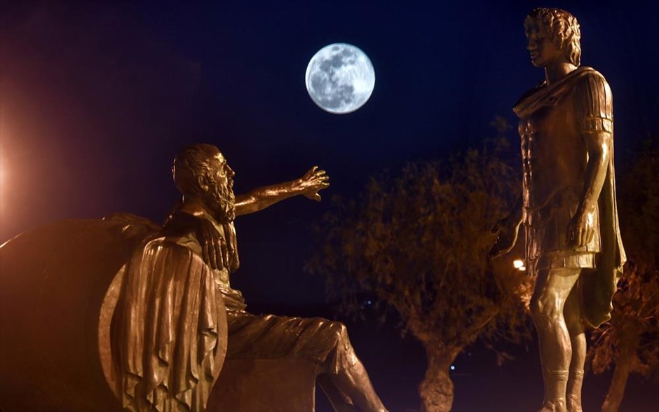 Υπερπανσέληνος στην Κόρινθο. Το άγαλμα του Διογένη με τον Μέγα Αλέξανδρο με φόντο την υπερπανσέληνο, στην περιοχή Καλάμια στο κέντρο της Κορίνθου. Όπως είχε επισημάνει η δημοτική αρχή στην τοποθέτησή του, «η γλυπτική σύνθεση των δύο αγαλμάτων επιλέχθηκε διότι συνδέεται με την κλασσική ιστορία της Κορίνθου και συγκεκριμένα αναπαριστά το πασίγνωστο περιστατικό της συνάντησης του Μεγάλου Αλεξάνδρου, του Έλληνα βασιλιά που μεταλαμπάδευσε τον ελληνικό πολιτισμό στα πέρατα του τότε γνωστού κόσμου, και του Διογένη, ενός εκ των διασημότερων και πιο αντιπροσωπευτικών στωικών φιλοσόφων της αρχαίας Ελλάδος».&nbsp;&nbsp;