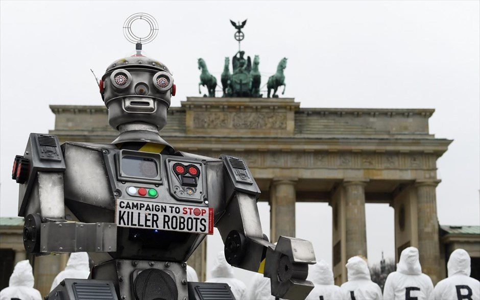 We are (not) the robots. Ακτιβιστές συγκεντρώνονται στην Πύλη του Βρανδεμβούργου στο Βερολίνο, αντιτιθέμενοι στα αυτόνομα φονικά όπλα, γνωστά και ως Killer Robots (ρομπότ-δολοφόνοι).