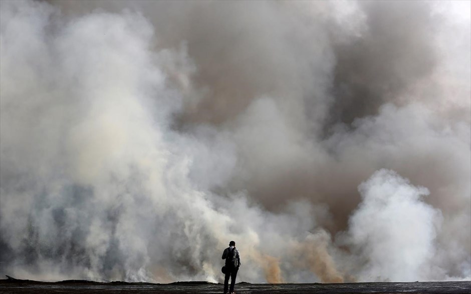 Φωτιά στην Ινδία. Ένας άνδρας παρακολουθεί τη φωτιά που καίει σε εργοστάσιο στις όχθες του Γάγγη ποταμού, στην Καλκούτα. 