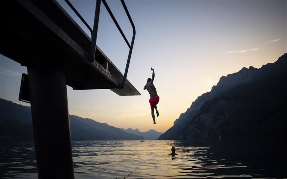 Βουτιές στην Ελβετία. Παρέα νεαρών απολαμβάνει το δειλινό βουτώντας από βατήρα, στην λίμνη Walensee.