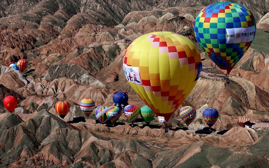 Φεστιβάλ αερόστατου στην Κίνα. Αερόστατα πετούν πάνω από το μαγευτικό σκηνικό στο Τσανγκγιέ (Κίνα). 