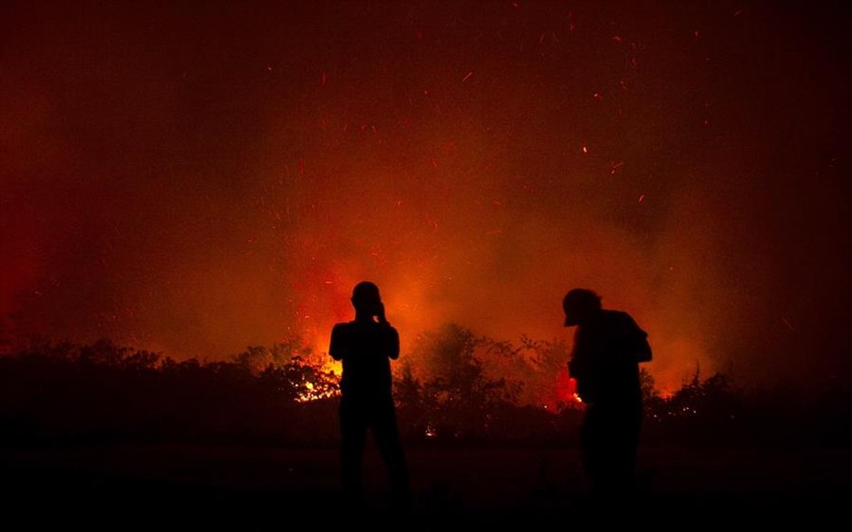 Φωτιές στην Ινδονησία. Κάτοικοι κοιτούν τις φλόγες να τυλίγουν περιοχή της&nbsp;πόλης Palangkaraya της Ινδονησίας.&nbsp;