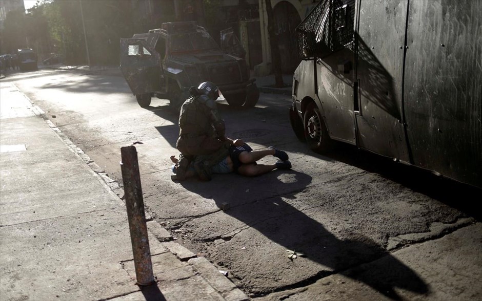 Σύλληψη διαδηλωτή στο Σαντιάγο. Μέλος των σωμάτων ασφαλείας συλλάμβάνει διαδηλωτή σε δρόμο του Σαντιάγο στην Χιλή