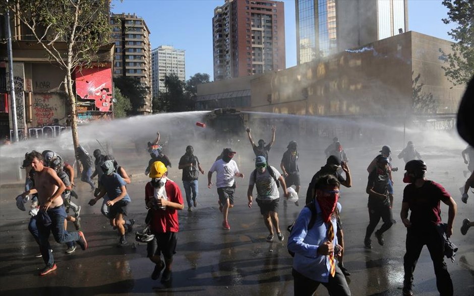 Αντικυβερνητικές διαδηλώσεις στη Χιλή. Διαδηλωτές τρέχουν να ξεφύγουν από τις αύρες της αστυνομίας κατά την διάρκεια αντικυβερνητικών διαδηλώσεων στο Σαντιάγο