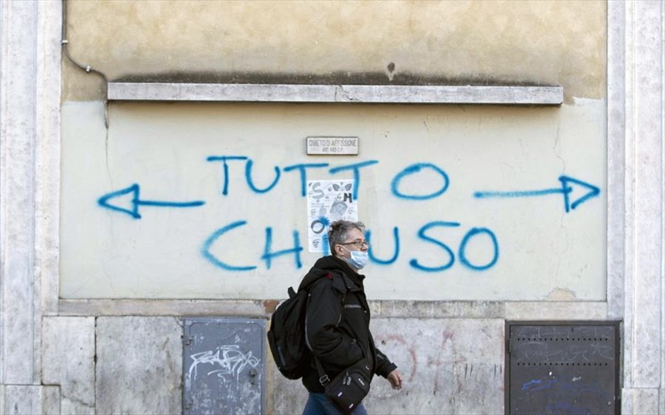 «Όλα κλειστά» . Ένας άνδρας περνάει μπροστά από τοίχο σε δρόμο της Ρώμης όπου αναγράφεται η φράση «Όλα κλειστά». Βάσει κυβερνητικού διατάγματος το οποίο τέθηκε σε ισχύ σήμερα, οι πολίτες απαγορεύεται να εισέρχονται ή να εξέρχονται από μεγάλες περιοχές της βόρειας Ιταλίας, περιλαμβανομένων του Μιλάνου, της Βενετίας και της Πάρμας, καθώς και μεγάλου μέρους της &nbsp;βιομηχανικής καρδιάς της Ιταλίας.&nbsp;Οι κάτοικοι στη ζώνη απομόνωσης δεν επιτρέπεται να ταξιδεύουν μέσα σε αυτήν, οι εργαζόμενοι πρέπει να λάβουν άδεια, ενώ οι ομάδες κινδύνου, όπως οι ηλικιωμένοι, παραμένουν στα σπίτια τους. Το διάταγμα αναφέρει ότι η αστυνομία και ο στρατός μπορούν να αναπτυχθούν για να επιβάλουν την απομόνωση, εάν είναι απαραίτητο. Οι άνθρωποι που παραβιάζουν τους κανόνες μπορούν θεωρητικά να βρεθούν αντιμέτωποι με ποινή φυλάκισης έως και τρεις μήνες.