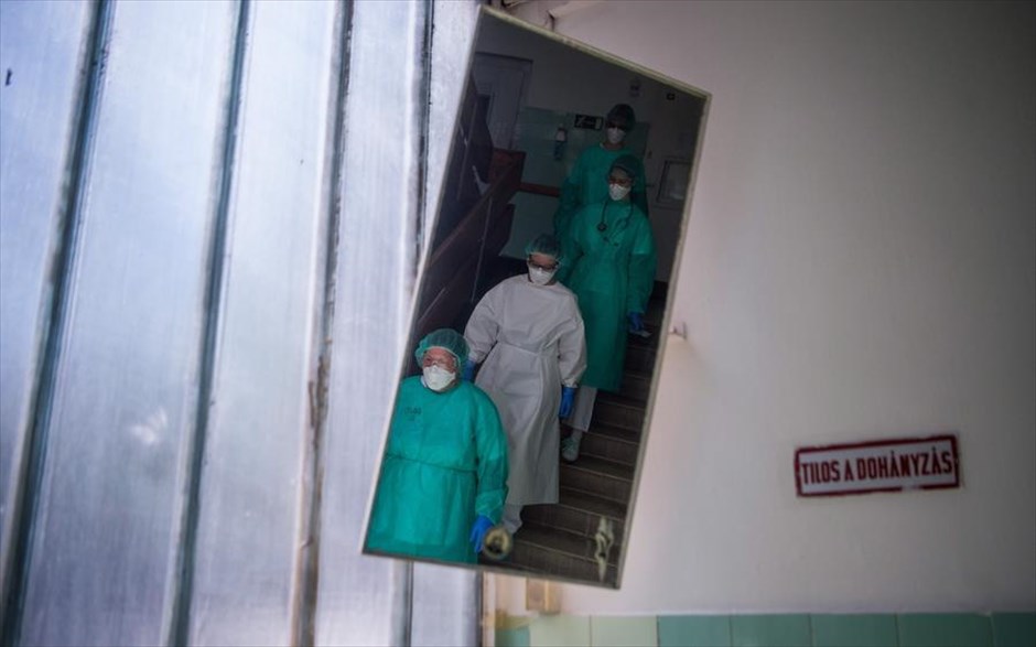 Εφημερίες στη Βουδαπέστη . Μια ομάδα γιατρών και νοσηλευτών διακρίνεται σε ένα καθρέφτη καθώς κατεβαίνει τις σκάλες ενός ορόφου για να επισκεφτεί το τμήμα ορθοπεδικής για τον κορωνοϊό του νοσοκομείου St. Janos στην Βουδαπέστη (Ουγγαρία). 