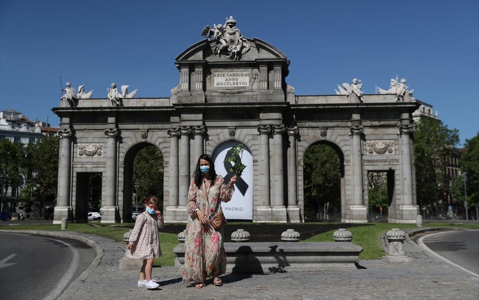Αέρινες βόλτες. Ένα κοριτσάκι φτιάχνει τη μάσκα καθώς απολαμβάνει τη βόλτα του μπροστά από την πύλη Πουέρτα δε Αλκαλά της Μαδρίτης (Ισπανία). 