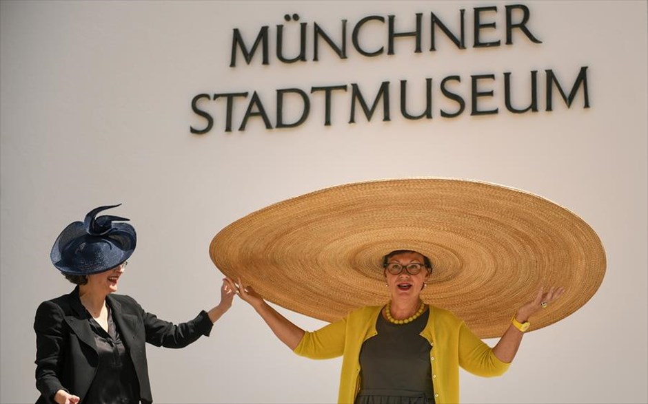 Καπέλο... κοινωνικής αποστασιοποίησης . Η σχεδιάστρια καπέλων Nicki Marquardt (αριστερά) και η διευθύντρια του μουσείου του Μονάχου Frauke von der Haar αστειεύονται στην παρουσίαση του γιγάντιου καπέλου του μουσείου, το οποίο είναι σχεδιασμένο για να τηρεί τα μέτρα κοινωνικής αποστασιοποίησης.  