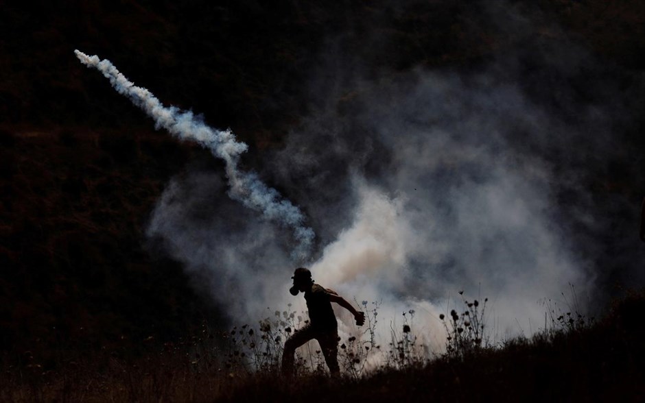 Ένταση και πάλι στην Δυτική Όχθη. Παλεστίνιος διαδηλωτής επιστρέφει δακρυγόνο που έριξαν οι ισραηλινοί στρατιώτες κατά την διάρκεια επεισοδίων στην Δυτική Όχθη