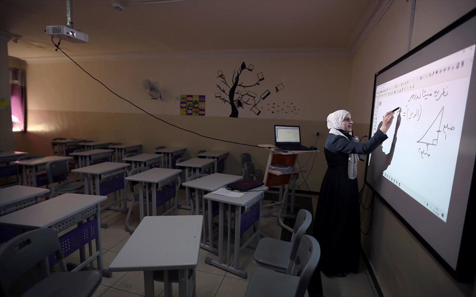 Το μάθημα συνεχίζεται παρά τις δυσκολίες. Μια δασκάλα παραδίδει το μάθημα της ημέρας μέσω τηλεδιάσκεψης σε ιδιωτικό σχολείο της Ιορδανίας