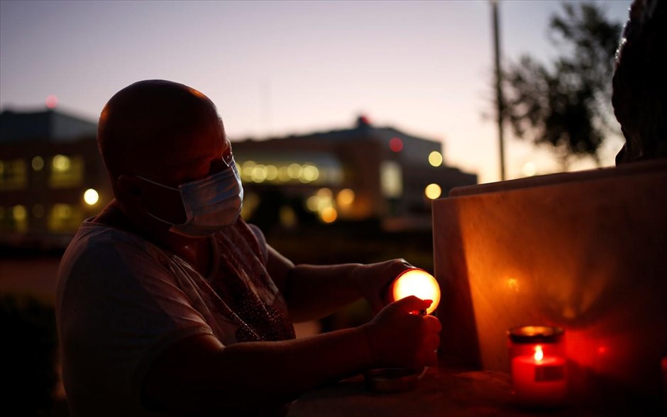 Κορωνοϊός υπο το φώς των κεριών. Ένα άτομο που φοράει προστατευτική μάσκα ανάβει ένα κερί κατά τη διάρκεια μιας επαγρύπνησης που υποστηρίζει τους φροντιστές και τους ηλικιωμένους την εποχή του κορωνοϊού στην Μάλτα