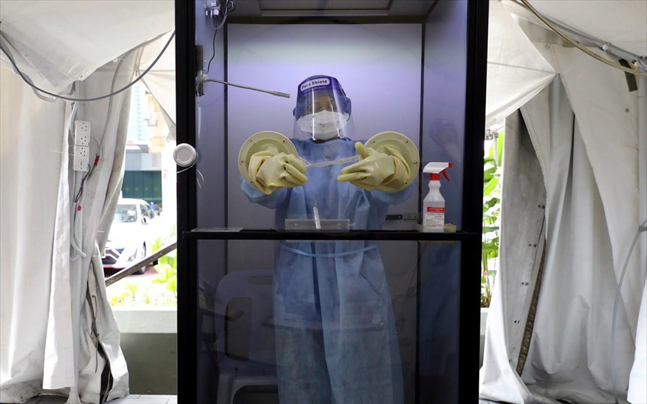 Ώρα για τέστ. Γιατρός μπαίνει σε προστατευόμενο χώρο για να πάρει τέστ απο ασθενή στην Μαλαισία