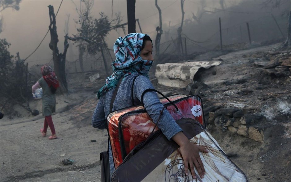 POY 2020. Μια γυναίκα κρατάει όσα πράγματα μπόρεσε να σώσει απο την πυρκαγιά που ξέσπασε στον καταυλισμό της Μόριας 