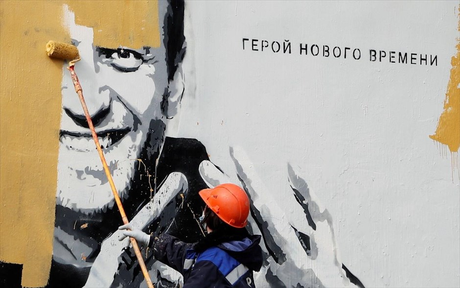 «Ο ήρωας της νέας εποχής». Ένας εργάτης , στην Αγία Πετρούπολη, καλύπτει με μπογιά ένα γκραφίτι που απεικονίζει τον φυλακισμένο πολιτικό της αντιπολίτευσης, Αλεξέι Ναβάλνι,&nbsp;με το σύνθημα: «Ο ήρωας της νέας εποχής»