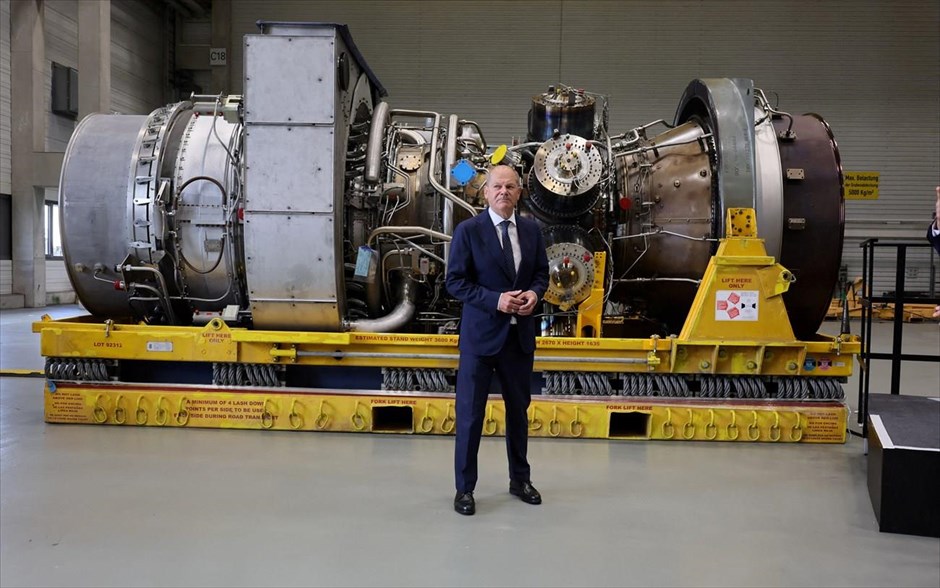 Στο βάθος τουρμπίνα. Ο Γερμανός καγκελάριος Όλαφ Σολτς στέκεται δίπλα στην τουρμπίνα που προορίζεται να μεταφερθεί στον σταθμό συμπίεσης του αγωγού φυσικού αερίου Nord Stream 1 στη Ρωσία. Ο Σολτς κατά την επίσκεψή του στο εργοτάξιο της Siemens Energy στο Μύλχαϊμ είπε ότι η τουρμπίνα είναι έτοιμη για να τεθεί σε λειτουργία ανά πάσα στιγμή. «Δεν υπάρχει τίποτα που να την εμποδίζει να μεταφερθεί στη Ρωσία», τόνισε. 