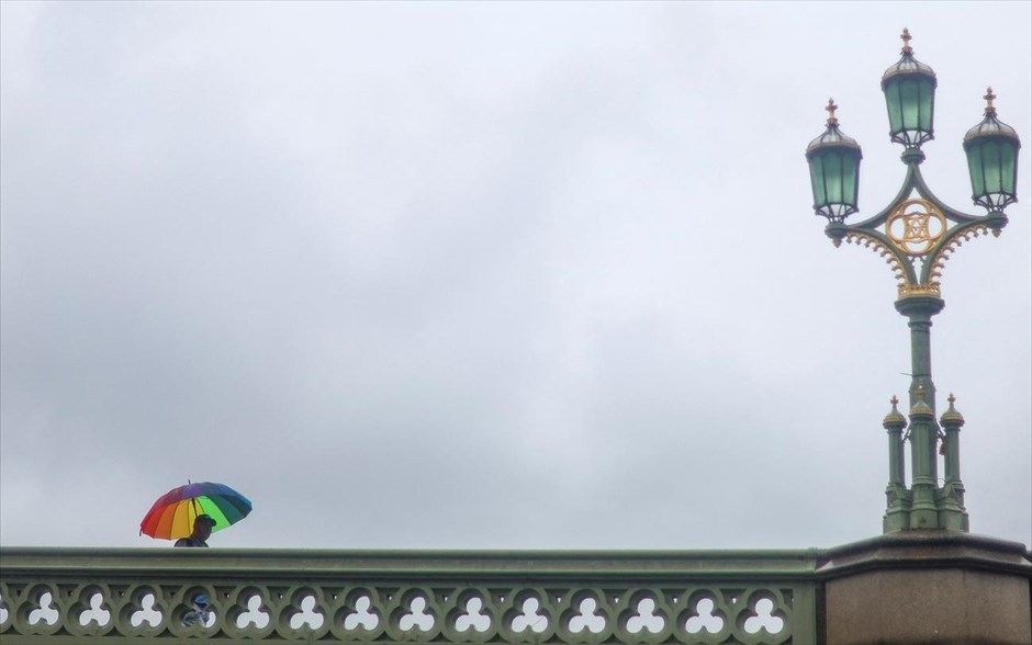 Βροχόπτωση στο Λονδίνο. Ένας πεζός κρατάει μια ομπρέλα περπατώντας στη Γέφυρα Ουεστμίνστερ, σε μια ημέρα με σφοδρή βροχόπτωση στο Λονδίνο.