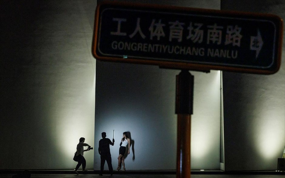 Βάρδια στο Πεκίνο. Ένας φωτογράφος βγάζει φωτογραφίες ενός μοντέλου κατά τη διάρκεια μιας υπαίθριας φωτογράφησης σε δρόμο του Πεκίνου, στην Κίνα. 