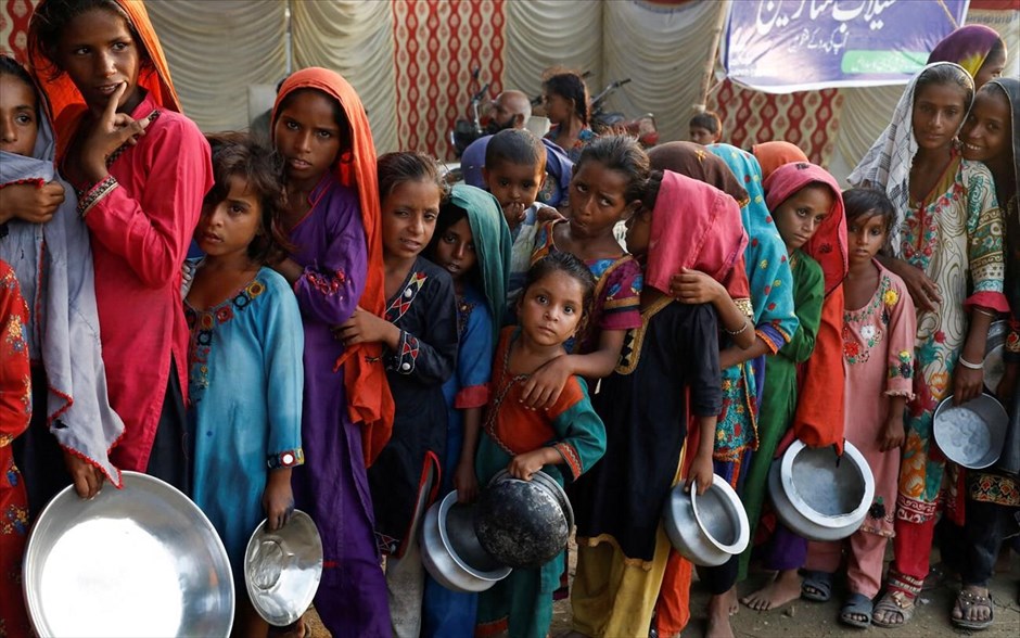 Στην ουρά. Οικογένειες που έχουν πληγεί από τις πλημμύρες συγκεντρώνονται σε καταυλισμό, στο Sehwan του Πακιστάν, για να λάβουν τρόφιμα.
 