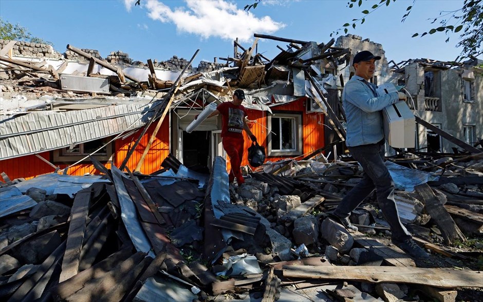 Στα συντρίμμια της Λουγκάνσκ. Δύο άνδρες απομακρύνουν αντικείμενα από τα συντρίμμια ενός κτιρίου που καταστράφηκε από πρόσφατους βομβαρδισμούς κατά τη διάρκεια της σύγκρουσης Ρωσίας-Ουκρανίας στην πόλη Καντίβκα στην περιοχή Λουγκάνσκ. 