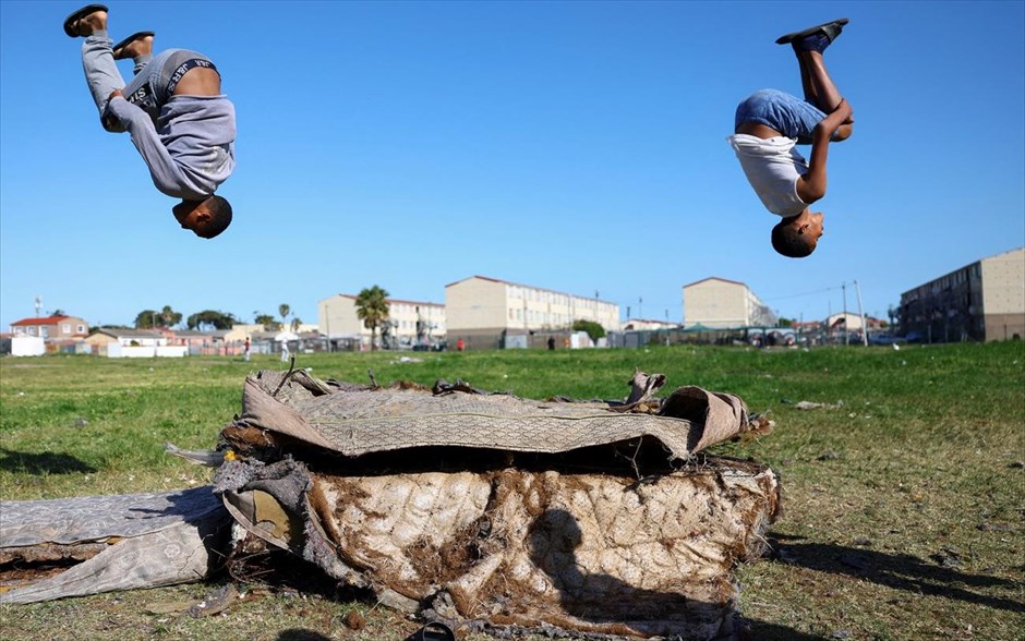 Παιχνίδια στον αέρα. Δύο αγόρια που παίζουν σε παλιά στρώματα στο Hanover Park, μια περιοχή που πλήττεται από τη συνεχιζόμενη βία συμμοριών στο Κέιπ Τάουν, στη Νότια Αφρική. 