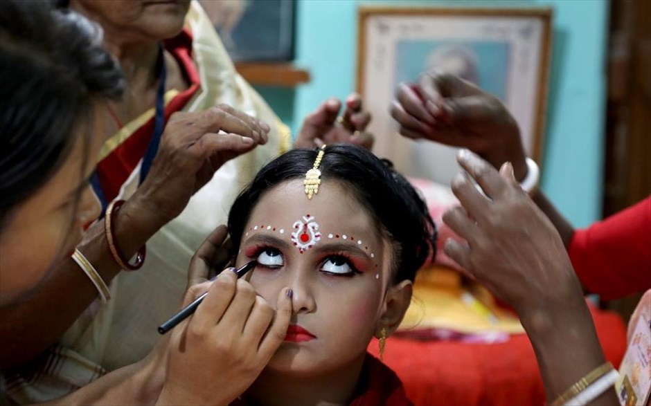 Τελετουργικά στην Ινδία. Ένα κορίτσι ετοιμάζεται ως θεά Ντούργκα κατά τη διάρκεια του τελετουργικού Kumari Puja, στο πλαίσιο του φεστιβάλ Durga Puja στο χωριό Shidaspur βόρεια της Καλκούτα, στην Ινδία. 