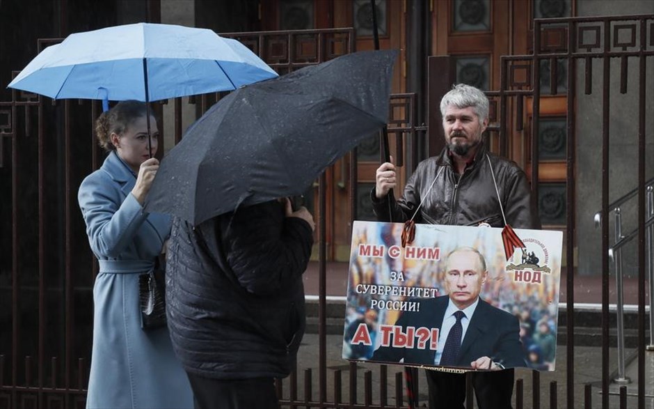 Οι πιστοί του Πούτιν. Ένας άντρας έξω από το κτίριο της Ρωσικής Κρατικής Δούμας στη Μόσχα, κρατά τη φωτογραφία του Βλαντίμιρ Πούτιν που γράφει: «Είμαστε μαζί του. Εσύ; Για την κυριαρχία της Ρωσίας». Η Κρατική Δούμα, η κάτω βουλή της Ομοσπονδιακής Συνέλευσης της Ρωσίας, επικύρωσε τις συμφωνίες για την προσάρτηση τεσσάρων κατεχόμενων ουκρανικών περιοχών στην Ρωσία. Η ενέργεια αυτή έρχεται μετά τα δημοψηφίσματα που διοργανώθηκαν και τα οποία τόσο η Ουκρανία όσο και η Δύση κατήγγειλαν ως καταναγκαστικά και παράνομα. 