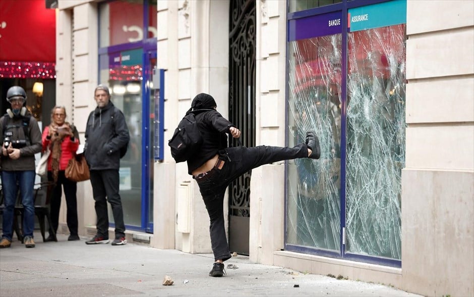 Επεισόδια στο Παρίσι. Ένας άνδρας σπάει την τζαμαρία μιας τράπεζας κατά τη διάρκεια διαδηλώσεων στο Παρίσι.