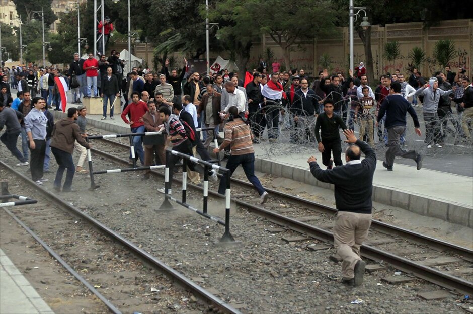 Τανκς και συγκρούσεις στο Κάιρο #29. Υποστηρικτές και αντίπαλοι του προέδρου της Αιγύπτου Μοχάμεντ Μόρσι συνέχισαν σήμερα να συγκρούονται έξω από το προεδρικό μέγαρο, παρά την ανάπτυξη τανκς και στρατιωτών μετά τα χθεσινά βίαια επεισόδια που στοίχισαν τη ζωή σε πέντε ανθρώπους. Οι ομάδες έριχναν πέτρες η μία στην άλλη, ενώ οι στρατιώτες καλούσαν τους διαδηλωτές να σταματήσουν τις συγκρούσεις και βοήθησαν να εκτονωθεί η ένταση, σύμφωνα με το Reuters. Τα βίαια επεισόδια έξω από το μέγαρο που ξέσπασαν χθες, είχαν σταματήσει τις πρώτες πρωινές ώρες σήμερα. Τουλάχιστον πέντε άνθρωποι σκοτώθηκαν και 350 τραυματίσθηκαν στις βιαιότητες, ανακοίνωσε το υπουργείο Υγείας.