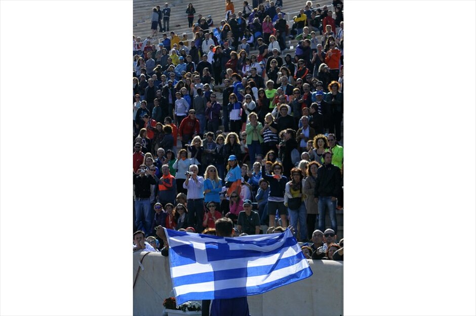 30ός Κλασικός Μαραθώνιος της Αθήνας #7. Μαραθωνοδρόμος τερματίζει στο Καλλιμάρμαρο στάδιο κρατώντας μία ελληνική σημαία. ΑΠΕ-ΜΠΕ/ΦΩΤΗΣ ΠΛΕΓΑΣ Γ.