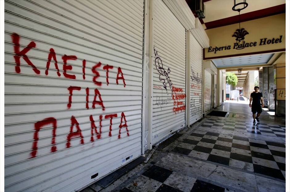 Ο ελληνικός τουρισμός στη σκιά της κρίσης #4. Ξένος τουρίστας περνάει μπροστά από το κλειστό ξενοδοχείο Esperia Palace στην Αθήνα, ένα από τα θύματα της οικονομικής κρίσης στην Ελλάδα. Στον τοίχο ένα γκράφιτι που γράφει «Κλειστά για πάντα» - 4 Ιουνίου 2012./