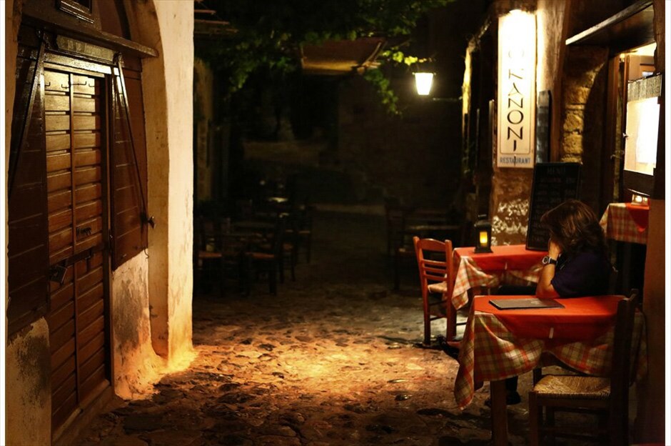 Ο ελληνικός τουρισμός στη σκιά της κρίσης #25. Μια γυναίκα κάθεται έξω από την ταβέρνα της στο μεσαιωνικό κάστρο της Μονεμβασιάς – 29 Μαΐου 2012./