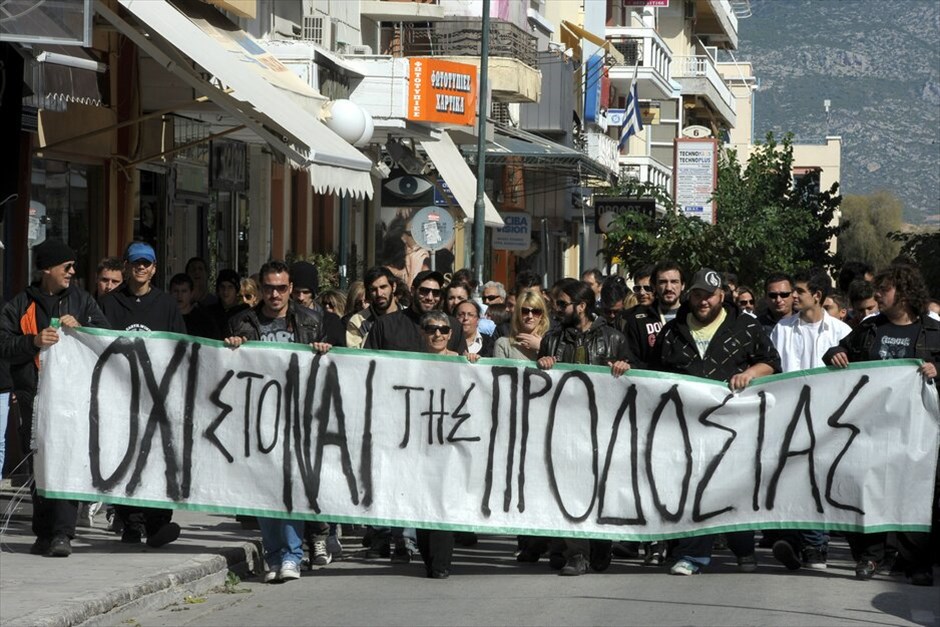 Διαμαρτυρίες και ματαιώσεις παρελάσεων σε πολλές πόλεις σε όλη την Ελλάδα #47. Στρατιωτική και μαθητική παρέλαση στην Κόρινθο με αισθητή την παρουσία των αγανακτισμένων και την απουσία των πολιτικών Αρχών, αρκετοί από τους μαθητές γύρισαν τα κεφάλια τους προς την απέναντι πλευρά των επίσημων όπου παρευρίσκονταν το πλήθος των αγανακτισμένων.