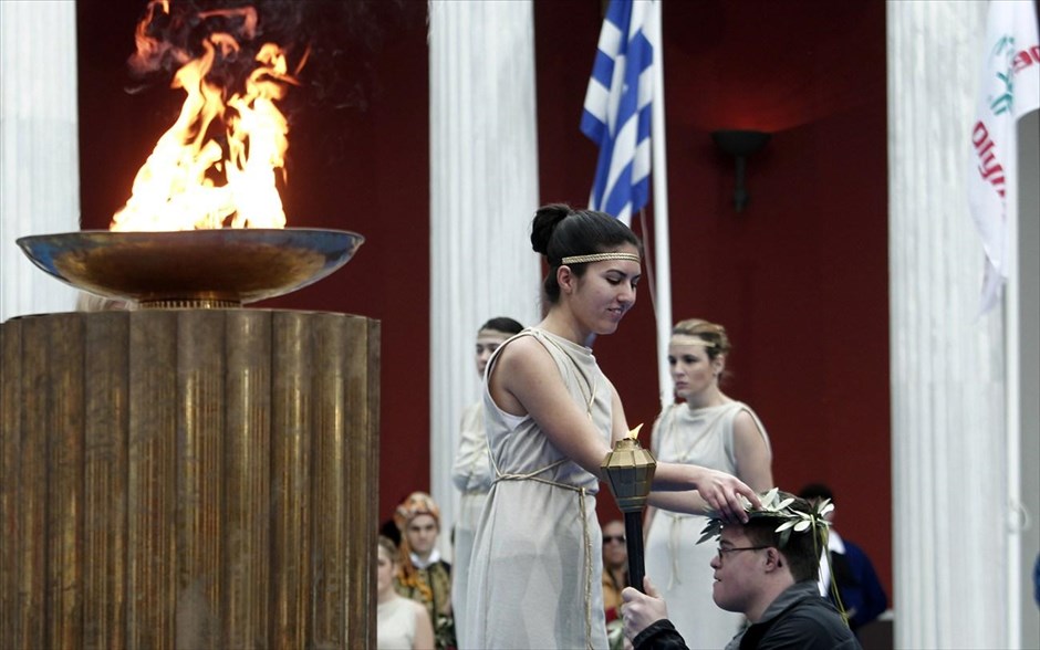 Special Olympics - Φλόγα για τους 10ους Παγκόσμιους Χειμερινούς Αγώνες το 2013 στη Νότια Κορέα. Ο Έλληνας λαμπαδηδρόμος Δημήτρης Κλαμπάνης λαμβάνει τον κότινο από την ιέρεια κατά τη διάρκεια της τελετής αφής της Φλόγας των Χειμερινών Special Olympics στο Ζάππειο Μέγαρο.