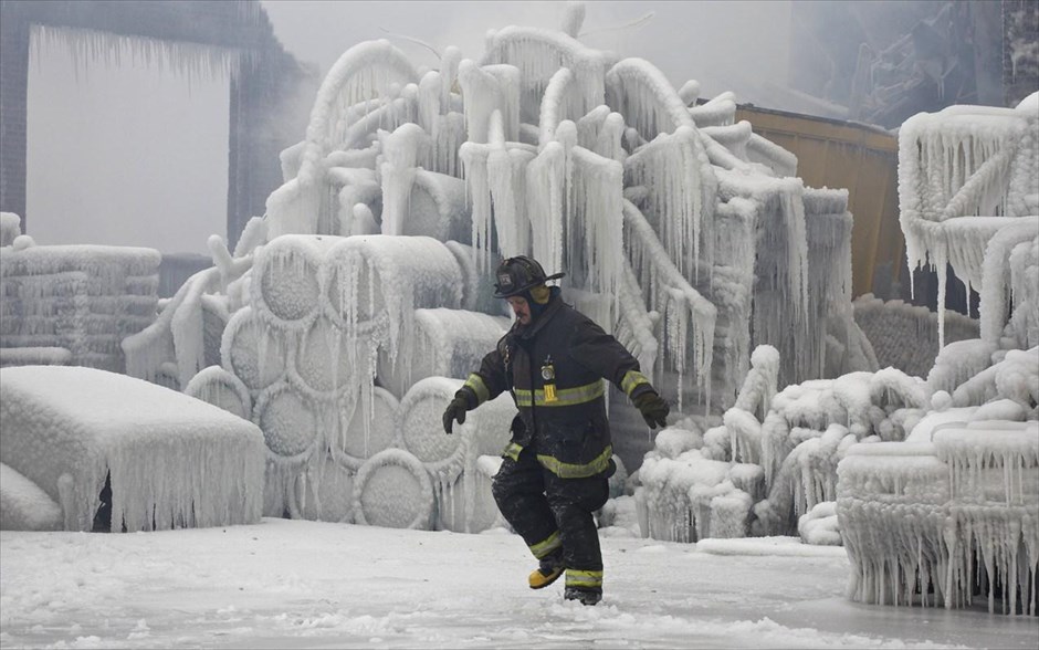 Φωτιά σε αποθήκη στο Σικάγο #7. Ο υπολοχαγός του τμήματος της Πυροσβεστικής του Σικάγο Charley De Jesus, περπατάει μπροστά από την καλυμμένη από πάγο αποθήκη που έπιασε φωτιά το βράδυ της Τρίτης στο Σικάγο, 22 Ιανουαρίου 2013.