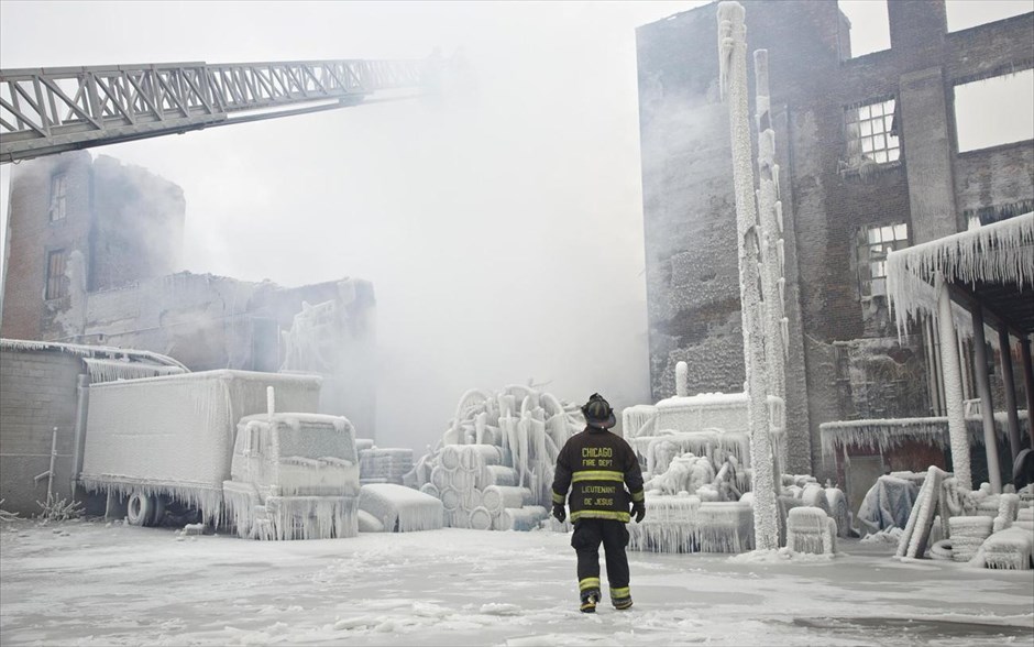 Φωτιά σε αποθήκη στο Σικάγο #14. Ο υπολοχαγός του τμήματος της Πυροσβεστικής του Σικάγο Charley De Jesus, περπατάει μπροστά από την καλυμμένη από πάγο αποθήκη που έπιασε φωτιά το βράδυ της Τρίτης στο Σικάγο.