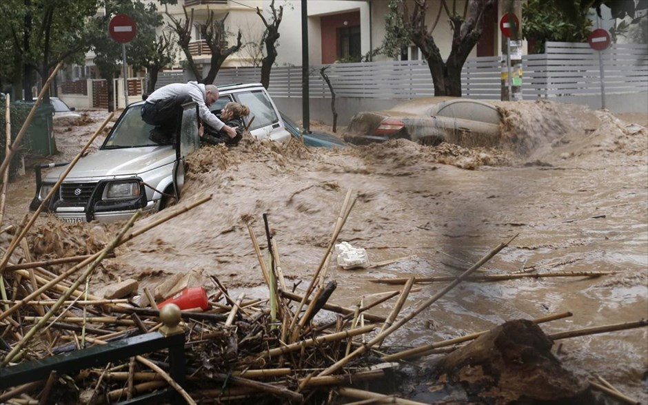 Αθήνα - καταρρακτώδης βροχή - Πλημμυρισμένοι δρόμοι - Χαλάνδρι - διάσωση. Γυναίκα που έχει παγιδευτεί στο αυτοκίνητό της από τα ορμητικά νερά χειμάρρου απεγλωβίζεται με τη βοήθεια κατοίκων του Χαλανδρίου.
A woman is rescued from flood waters by a resident standing on top of her car during heavy rain in Chalandri suburb north of Athens February 22, 2013. REUTERS/John Kolesidis (GREECE - Tags: DISASTER TPX IMAGES OF THE DAY ENVIRONMENT)