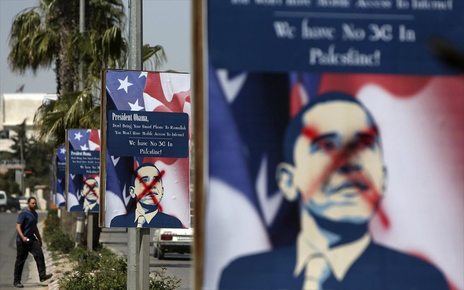 Επίσκεψη του Μπαράκ Ομπάμα στη Μέση Ανατολή την επόμενη βδομάδα. Ενας Παλαιστίνιος περπατάει δίπλα σε μουντζουρωμένες αφίσες του αμερικανού προέδρου Μπαράκ Ομπάμα, στην πόλη Ραμάλα, στη Δυτική Οχθη. Ο Ομπάμα σκοπεύει να επισκεφθεί το Ισραήλ, τη Δυτική Οχθη και την Ιορδανία την επόμενη βδομάδα.