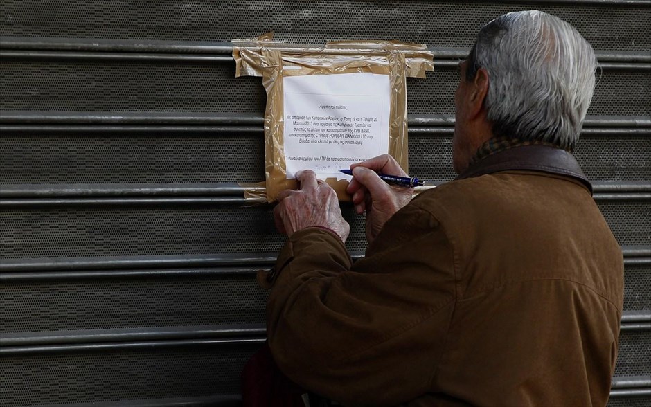 Ανησυχία στους έλληνες καταθέτες. Καταθέτης της Λαϊκής Τράπεζας της Κύπρου γράφει τη λέξη «αίσχος» σε ένα χαρτί που πληροφορεί τους πελάτες της τράπεζας ότι τα υποκαταστήματα της στην Ελλάδα θα παραμείνουν κλειστά ως την Πέμπτη το πρωί. Σε αναστάτωση βρίσκονται οι καταθέτες κυπριακών τραπεζών μετά την απόφαση που λήφθηκε στο Eurogroup για φορολόγηση των κατατεθειμένων χρημάτων τους.