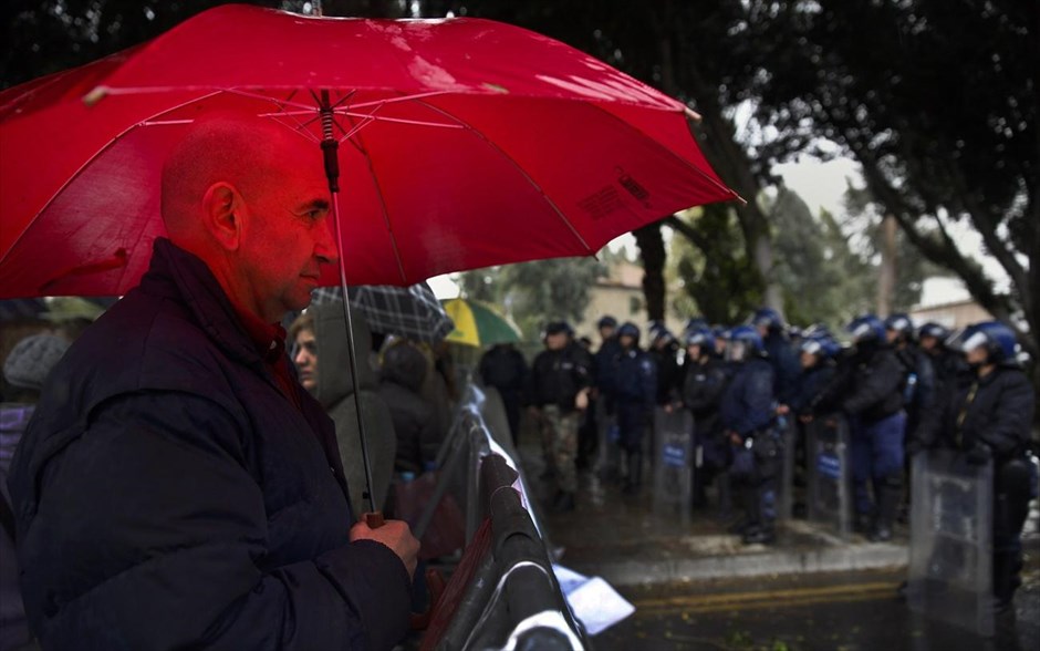 Κύπρος - Συγκέντρωση τραπεζοϋπαλλήλων έξω από τη Βουλή. Ο 53χρονος υπάλληλος της Λαϊκής Τράπεζας, Ανδρέας Χρυσάφης, στέκεται στη βροχή μπροστά από το μπλόκο της αστυνομίας έξω από τη Βουλή στη Λευκωσία, κατά τη διάρκεια της διαμαρτυρίας των τραπεζοϋπαλλήλων και των πολιτών για το «κούρεμα» των καταθέσεων και το κυπριακό μνημόνιο.