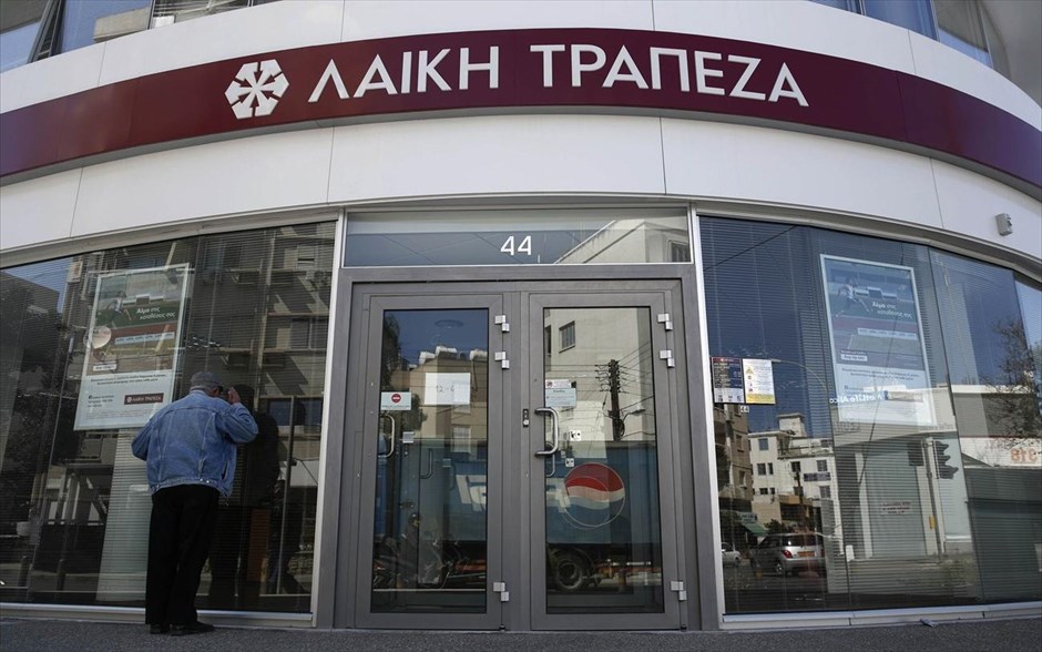 Κύπρος - Λαϊκή Τράπεζα - άνοιξαν οι κυπριακές τράπεζες #4. Πελάτης κοιτάει στο εσωτερικό καταστήματος της Λαϊκής Τράπεζας λίγο πριν το άνοιγμα των τραπεζών στη Λευκωσία.&nbsp;&nbsp;Οι τράπεζες στη χώρα άνοιξαν και πάλι την Πέμπτη με αυστηρούς ελέγχους στις συναλλαγές για να αποφευχθεί η φυγή καταθετών.